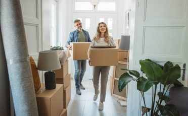 Mature couple moves in to their new home, unpacking boxes and enjoying the time together.